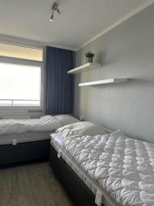 una camera da letto con due letti e una finestra di Strandhotel Wohnung 42 a Dahme