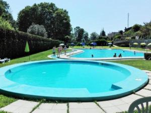 une grande piscine bleue avec des personnes debout autour de celle-ci dans l'établissement Corredoura Garden, à Caldelas