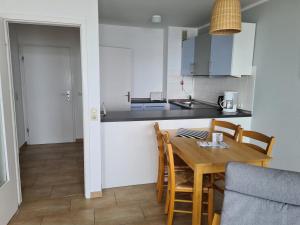 a kitchen and dining room with a wooden table and chairs at Strandhotel Wohnung 48 in Dahme