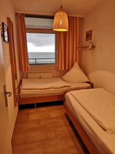 a small room with two beds and a window at Strandhotel Wohnung 48 in Dahme