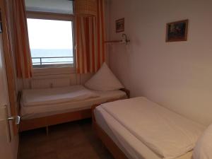 a small room with two beds and a window at Strandhotel Wohnung 48 in Dahme