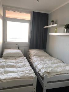 due letti in una stanza con finestra di Strandhotel Wohnung 59 a Dahme