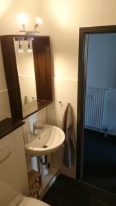 un bagno con lavandino, specchio e doccia di Strandhotel Wohnung 59 a Dahme