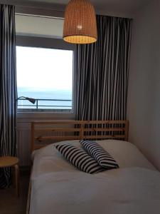 a bedroom with a bed with a large window at Strandhotel Wohnung 62 in Dahme