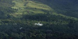 a large white house in the middle of a mountain at Fort Munnar in Chinnakanal