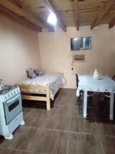 a bedroom with a bed and a table and a stove at Macrigaluma Luna in Barra del Chuy