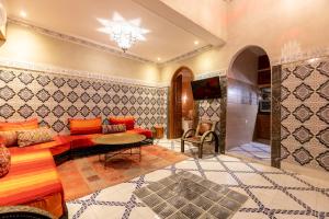un soggiorno con un divano e un tavolo di Riad Dali a Marrakech Altre 3 foto