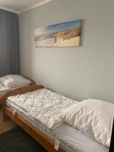 una camera da letto con due letti e un dipinto sul muro di Strandhotel Wohnung 69 a Dahme