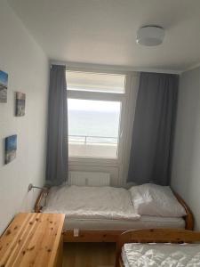 a small bedroom with a bed and a window at Strandhotel Wohnung 69 in Dahme