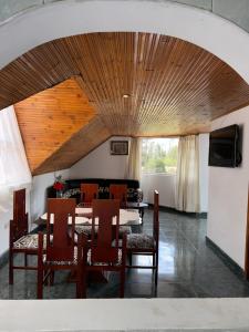 a dining room with a table and chairs and a television at Cabaña El Recuerdo, Paipa in Paipa
