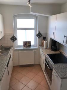 eine Küche mit einem Waschbecken und einem Fenster darin in der Unterkunft Villa Baltica Wohnung 01 in Dahme