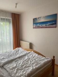 ein unverbautes Bett in einem Schlafzimmer mit einem Fenster in der Unterkunft Villa Seewind Wohnung 9 in Dahme