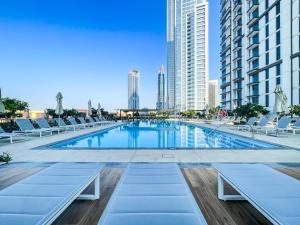 una gran piscina con tumbonas y edificios en Amazing Apartment with City Views in Downtown 164BC-2, en Dubái