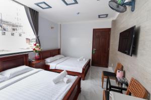 a hotel room with two beds and a window at Sunny Guesthouse in Ho Chi Minh City
