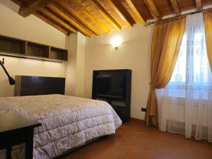 a bedroom with a bed and a flat screen tv at Lilium Domus in Florence