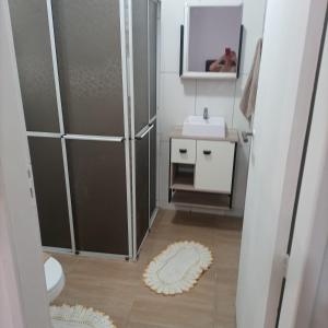 een badkamer met een douche, een wastafel en een toilet bij Residencial Dona Preta in Florianópolis