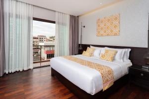 a bedroom with a large bed and a large window at Mintra Hotel in Vientiane