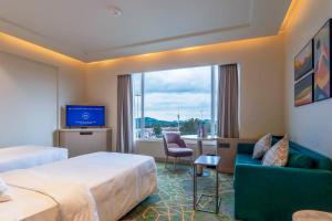 a hotel room with two beds and a tv at Holiday Inn Katra Vaishno Devi, an IHG Hotel in Katra
