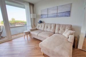 un soggiorno con divano e una grande finestra di Haus Schöne Aussicht, App 2SBE12 a Heiligenhafen