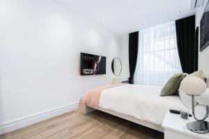 Habitación blanca con cama y ventana en Luxury 2 Bedroom Apartment in Central London en Londres