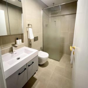 y baño con lavabo, aseo y ducha. en Cozy apartment with Pool - 10 mins from Dubai Marina, en Dubái
