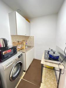 a kitchen with a washing machine and a stove at Roxy Hostel in Abu Dhabi