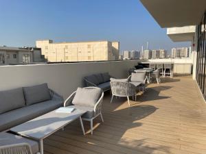 Un balcón con sofás, mesas y sillas en un edificio en Cozy apartment with Pool - 10 mins from Dubai Marina, en Dubái