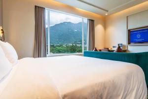 a bedroom with a large bed and a large window at Holiday Inn Katra Vaishno Devi, an IHG Hotel in Katra
