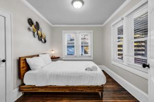 a white bedroom with a bed and two windows at Charlotte Luxury Home NoDa in Charlotte