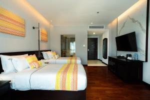 a hotel room with two beds and a flat screen tv at Mintra Hotel in Vientiane