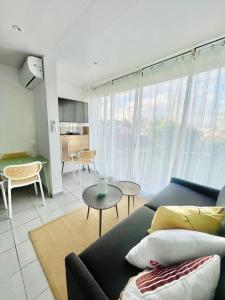 a living room with a couch and a table at Appartement Belbo de la Marina in Les Trois-Îlets