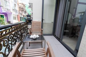 a balcony with a table and chairs on it at Sunny Guesthouse in Ho Chi Minh City