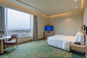 a hotel room with a bed and a large window at Holiday Inn Katra Vaishno Devi, an IHG Hotel in Katra