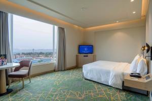格德拉Holiday Inn Katra Vaishno Devi by IHG的一间带床和大窗户的酒店房间
