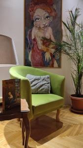a green couch in a living room with a painting at Bohemian Home in Skopje