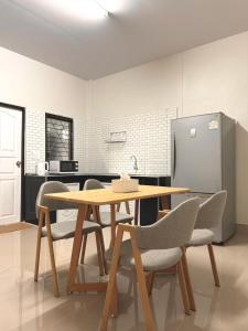 uma cozinha com uma mesa e cadeiras e um frigorífico em Pk house and cosy em Betong