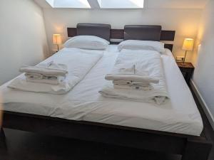 a large bed with white sheets and towels on it at Yachthafenresidenz-Wohnung-8411-871 in Kühlungsborn