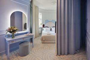 a bedroom with a bed and a dressing table and a mirror at Zamek Łeba Resort & Spa in Łeba