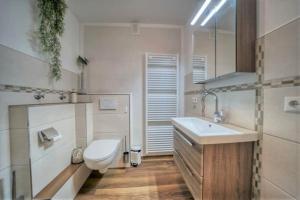 een badkamer met een wit toilet en een wastafel bij Strandhotel, App 4SH303 in Heiligenhafen