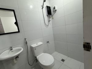 a white bathroom with a toilet and a sink at RedDoorz near Mariners Legazpi in Legazpi