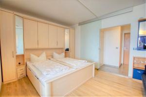 ein Schlafzimmer mit einem großen weißen Bett in einem Zimmer in der Unterkunft Strandhotel, App 3SH219 in Heiligenhafen