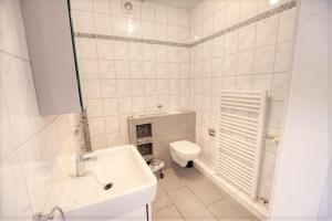 ein weißes Bad mit einem WC und einem Waschbecken in der Unterkunft Strandhotel, App 3SH219 in Heiligenhafen