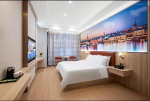 Un dormitorio con una gran cama blanca y una pintura en President Hotel Shenzhen - Yitian Metro Station, en Shenzhen