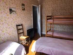 1 Schlafzimmer mit 2 Etagenbetten und einem Stuhl in der Unterkunft Chambre 2 dans un appartement in Bourg-en-Bresse