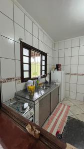 uma cozinha com um lavatório e uma bancada em Suítes em Ubatuba em Ubatuba
