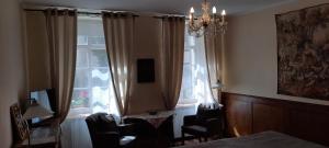 a bedroom with a window with chairs and a chandelier at Altstadtapartment Rochusstraße in Mainz