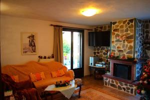 a living room with a bed and a fireplace at YourLittleMiracle-PanoramicView+FirePit+Garden+BBQ in Argalasti