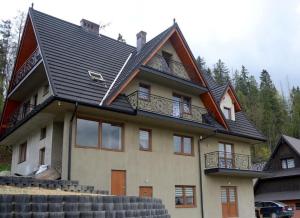 a house with a gambrel roof on top of it at Willa Pod Lasem in Biały Dunajec