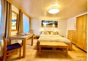 1 dormitorio con cama, mesa y escritorio en Haus Walch, en Elbigenalp