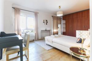 a bedroom with a bed and a desk and a piano at Laranjeiras Deluxe by Homing in Lisbon